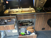 A VW T5 Campervan called Herve and Lots of storage including shallow drawer above fridge, deep drawer for kitchen equipment and storage hatch under worktop for hire in Gifford, East Lothian