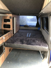 A VW T5 campervan called Herve and Rear seats fold down to bed that sleeps two (self inflating mat available). Black curtains throughout. for hire in Gifford, East Lothian